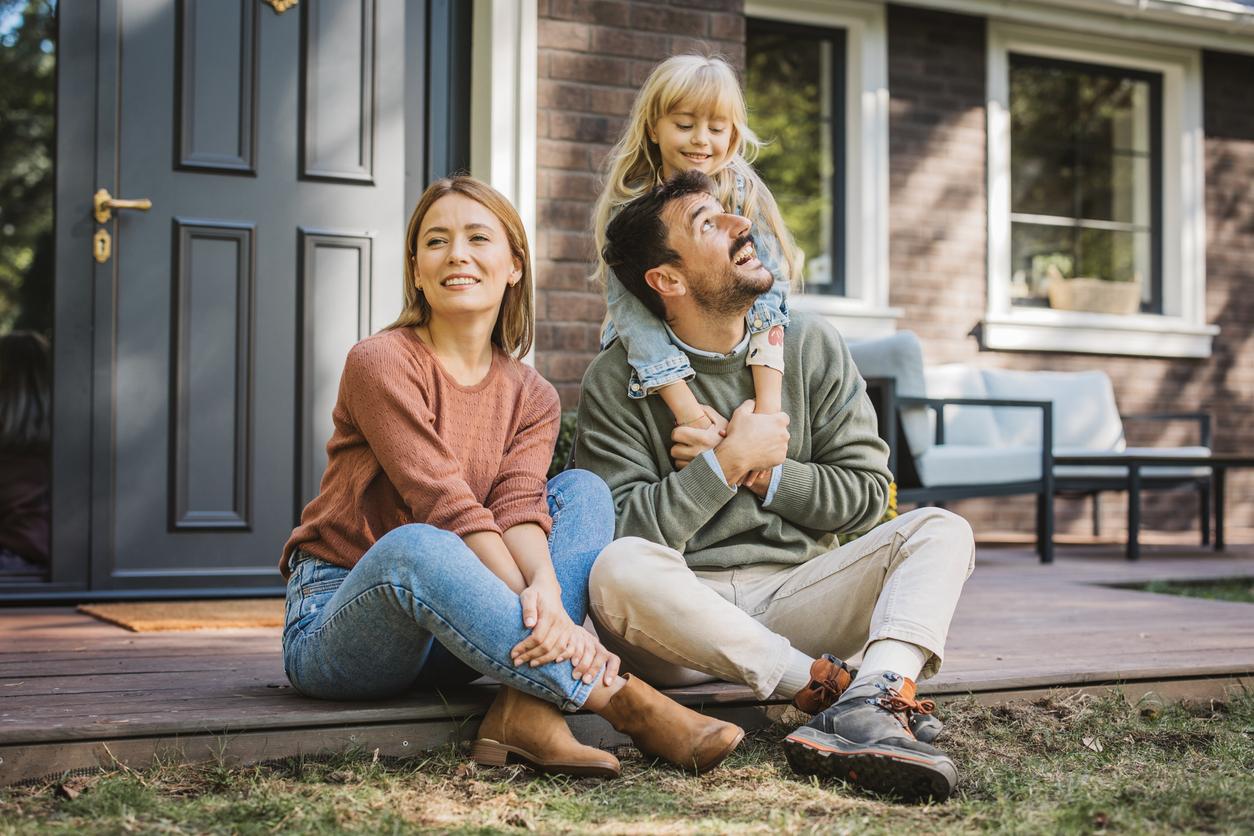 Family on front porch of a house after a move.
